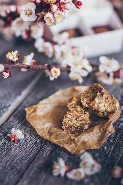 Foto frühlingskollektion handgemachter schokoladenbonbons und kirschblumendekoration auf rustikalem holzhintergrund.