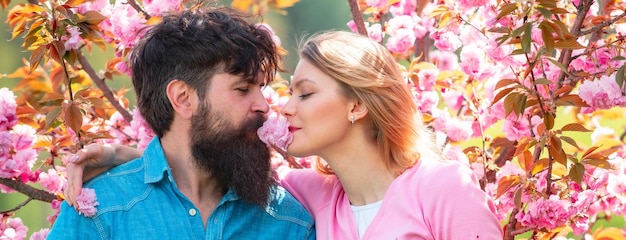 Frühlingspaar in Liebesbanner Glückliches junges Paar, das sich ansieht und küsst, während es den Valentinstag feiert