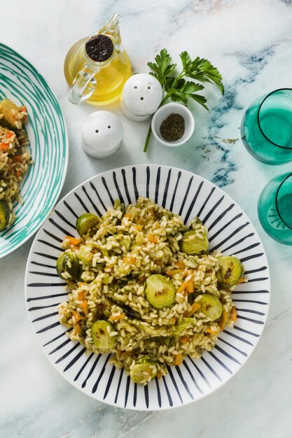 Frühlingsrisotto auf einem Marmortisch mit Gewürzen und Olivenöl