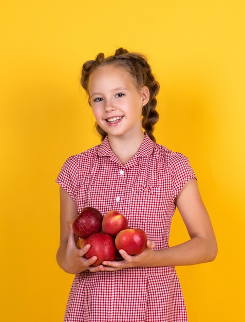 Frühlingsstil glückliches Mädchen, das Äpfel aus dem Garten hält Kind hält frisches Obst Kind isst roten Apfel Sommer gesunde Ernährung Vegetarische Ernährung Früchte bei Herbsternte Gesunde Ernährung im Herbst