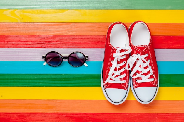 Frühlingsstimmung Kleidung, Gummischuhe und Brillen auf Regenbogen mehrfarbig
