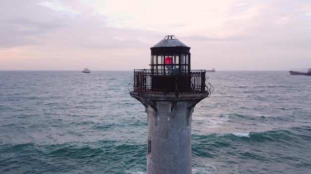 Frühmorgens bei Sonnenaufgang mit einer Drohne um den Leuchtturm fliegen