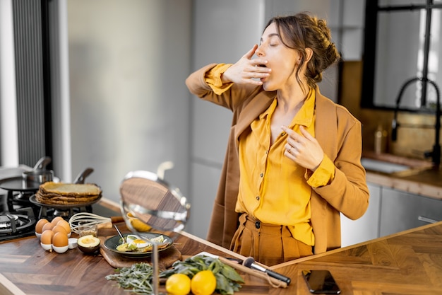 Frühmorgens verschlafene Bisnessfrau in der Küche