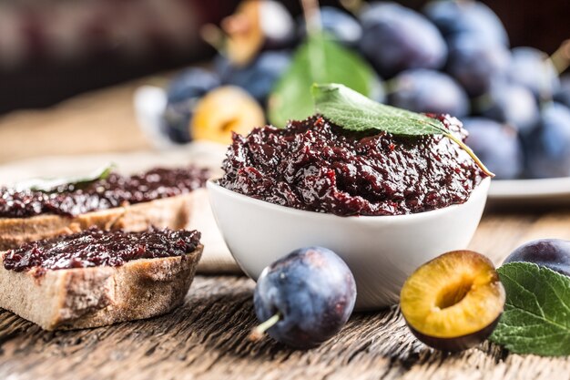 Frühstück aus hausgemachtem Pflaumenmarmeladebrot und frischen reifen Pflaumen.