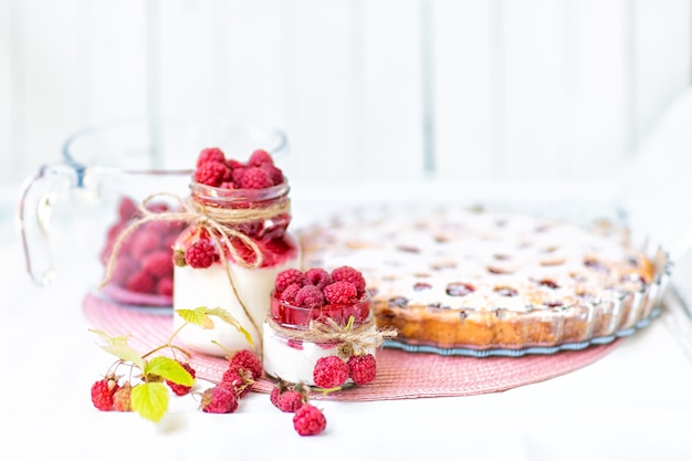 Frühstück, Desserts. Joghurt mit Himbeersirup und Himbeerbeeren und Himbeerkuchen