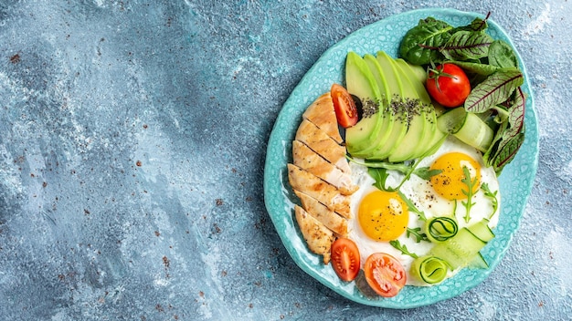 Frühstück Gegrilltes Hähnchenfilet mit Salat, frischen Tomaten, Gurken, Eiern und Avocado