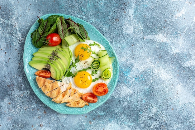 Frühstück Gegrilltes Hähnchenfilet mit Salat, frischen Tomaten, Gurken, Eiern und Avocado