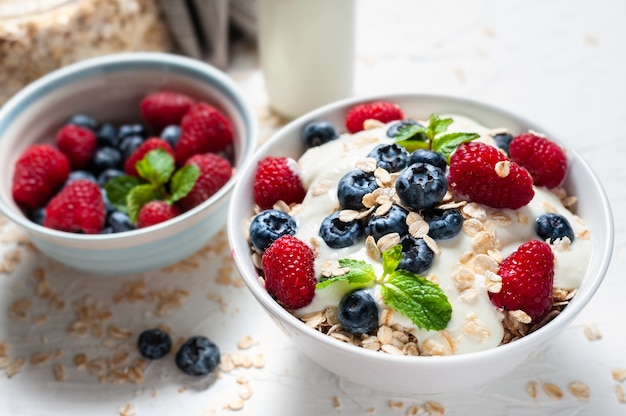 Frühstück, Hafermehl mit Blaubeere und Himbeere auf weißer Schüssel morgens.