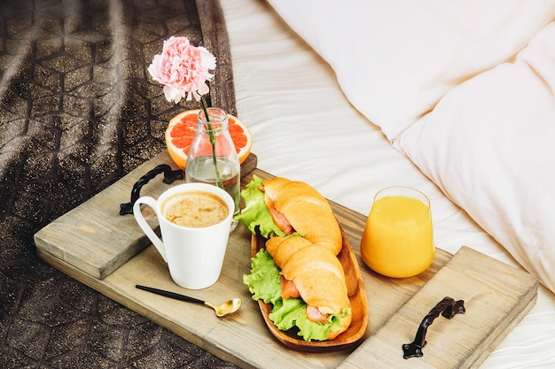 Frühstück im Bett auf einem Holztablett