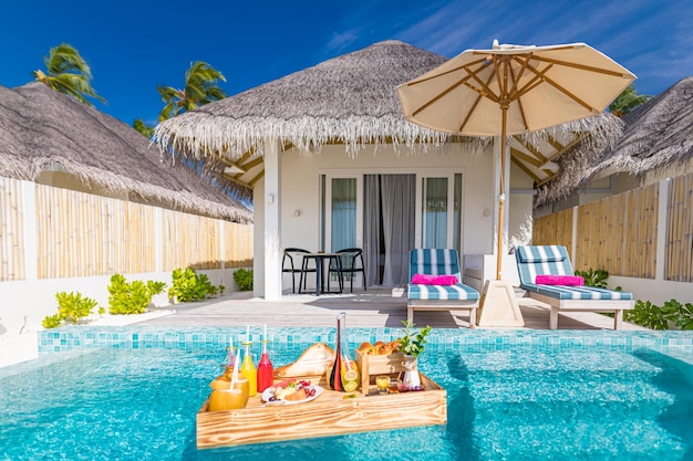 Frühstück im Swimmingpool, schwimmender Frühstückstisch im luxuriösen tropischen Resort. Strandvilla-Stühle