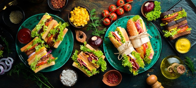 Frühstück Klassische Sandwiches mit Wurst, Schnitzel, Salat, Zwiebeln, Tomaten und Gemüse. Rustikaler Stil. Freier Kopierraum