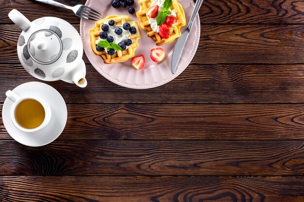 Frühstück mit belgischen Waffeln auf dunklem Holz