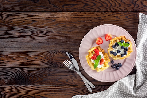 Frühstück mit belgischen Waffeln auf dunklem Holz