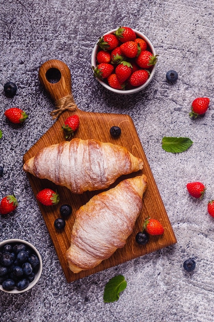 Frühstück mit Croissants und frischem Obst, Ansicht von oben.