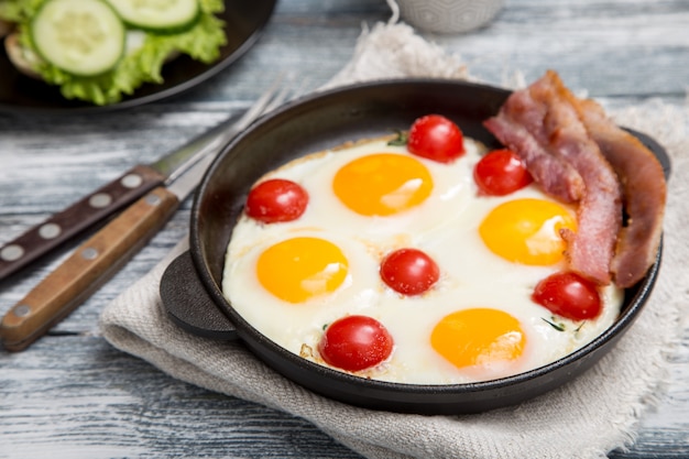 Frühstück mit Eiern, Kirschtomaten, Speck und frisch geröstetem Toast