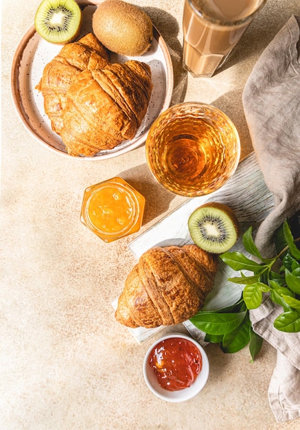 Frühstück mit einer Tasse Kaffee frische knusprige Croissant Marmelade Kiwi und Saft