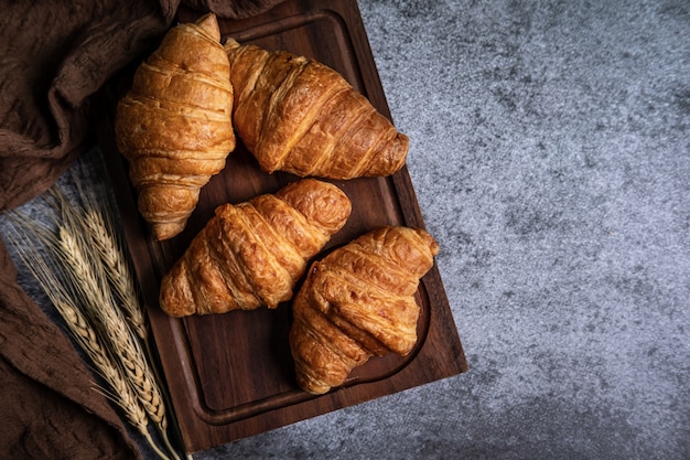 Frühstück mit frischen Croissants auf Holzbrett