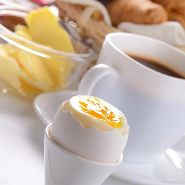 Foto frühstück mit gekochten ei-kaffee-croissants