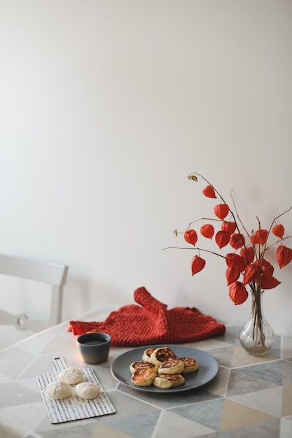 Frühstück mit hausgemachten Quarkpfannkuchen, einer Tasse Tee und Blumen in einer Vase auf dem Tisch