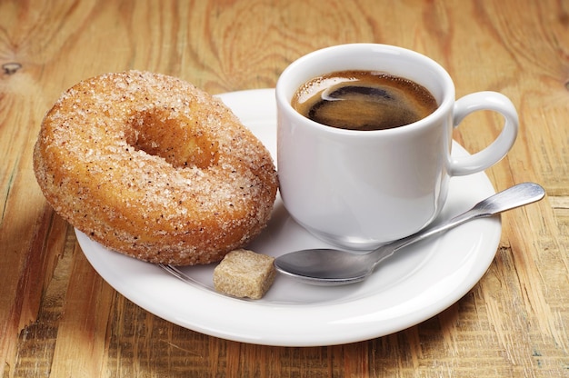 Frühstück mit heißem Kaffee und Donut auf altem Holztisch