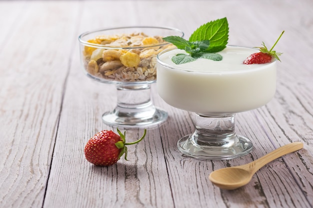 Frühstück mit Joghurt und Haferflocken auf einem Holztisch