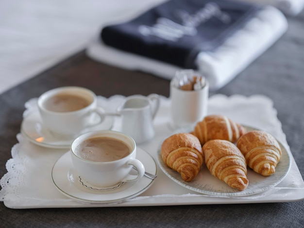 Frühstück mit Kaffee und Croissant im Hotelzimmer