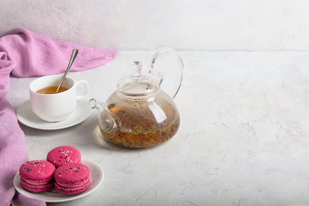 Frühstück mit Kräutertee mit Lavendel und süßen bunten Dessert-Macarons auf weißem Hintergrund