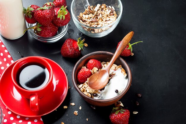 Frühstück mit Müsli, Beeren und einer Tasse Kaffee