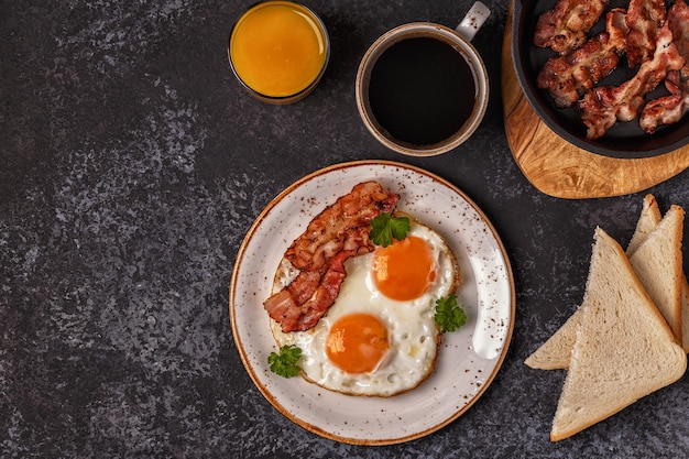 Frühstück mit Speck, Spiegelei, Kaffee und Orangensaft