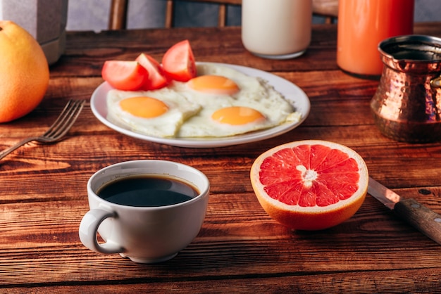 Frühstück mit türkischem Kaffee, Spiegeleiern, Saft und Obst