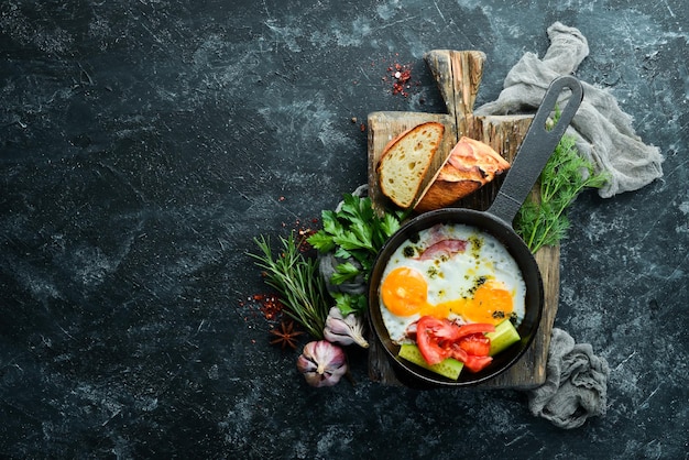 Frühstück Spiegeleier mit Speck und Gemüse in einer Bratpfanne Draufsicht Kostenloser Kopierbereich