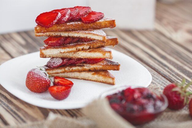 Frühstück. Toast mit Erdbeere und Marmelade. Brot und Confiture. Frischer heißer Toast mit Sahne. Leckeres hausgemachtes Dessert.