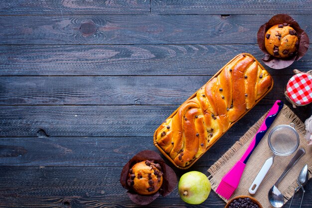 Frühstücken Sie mit unterschiedlichem Gebäck und Früchten auf einem hölzernen