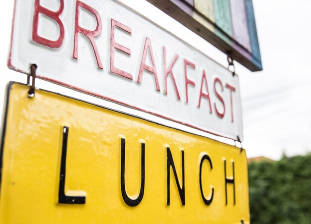 Frühstücks-Mittagessen-Schild auf den Metalltafeln. Es ist zur Straße und zum Café geschlossen.