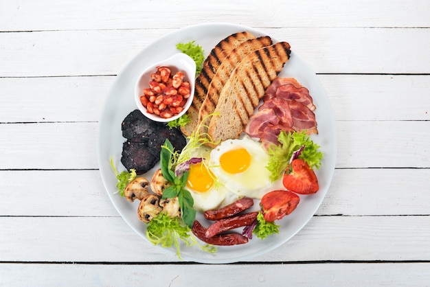 Frühstückseier mit Speck und Tomaten Toastbrot Draufsicht auf Holzhintergrund Kopierbereich