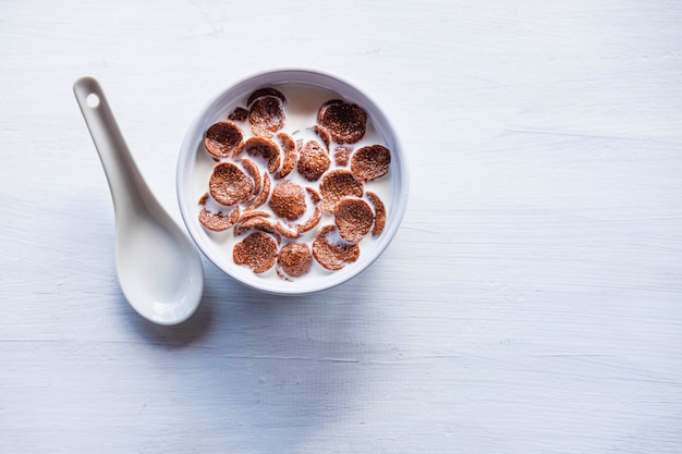 Frühstücksflocken mit frischer Milch auf dem weißen Tisch