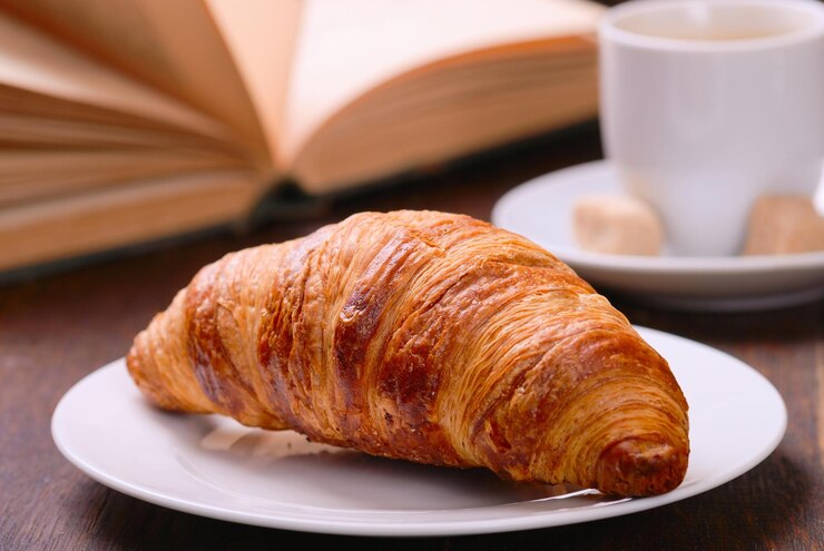 Frühstückskaffee-Croissant auf Holzhintergrund