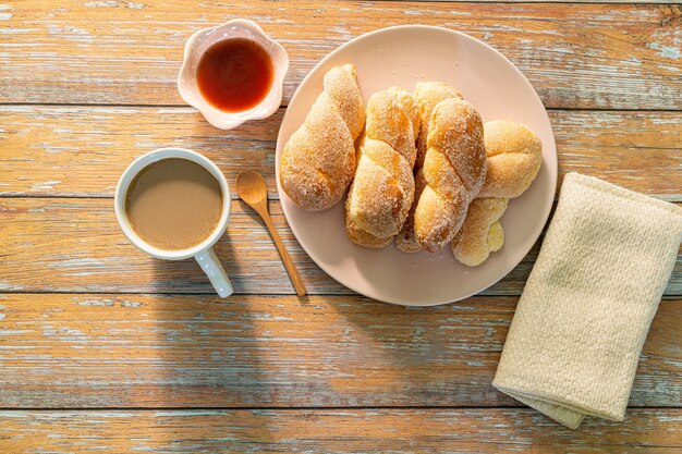 Frühstückskaffee und BrotFrühstück mit Kaffee und Croissants auf Holztisch