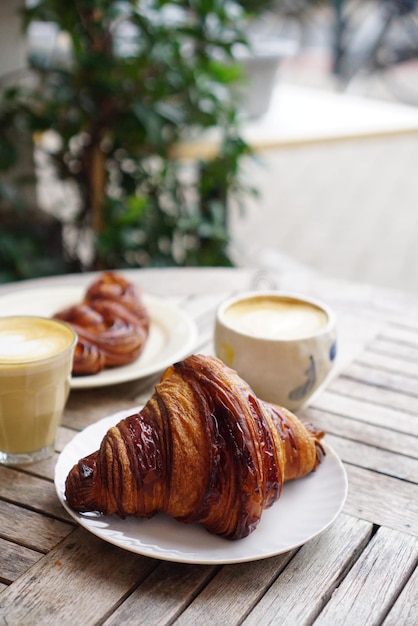 Foto frühstückskonzept foto von croissant und kaffee auf dem tisch im freien