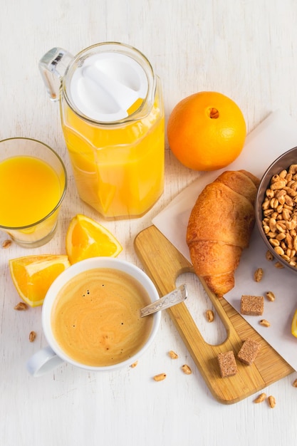 Frühstückskonzept Orangensaft Croissant und Kaffee auf weißem Hintergrund