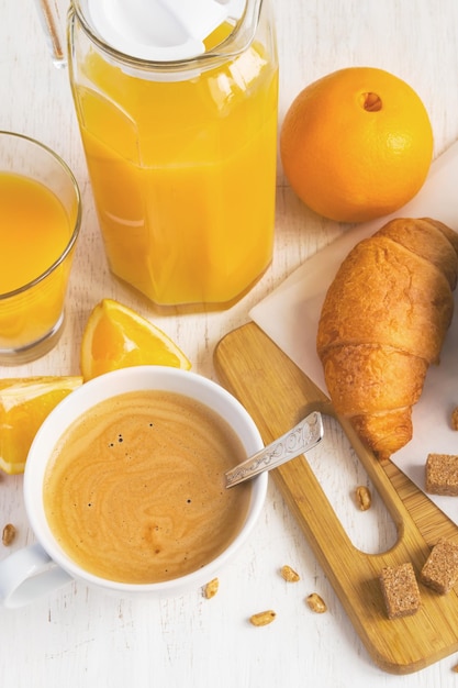 Frühstückskonzept Orangensaft Croissant und Kaffee auf weißem Hintergrund