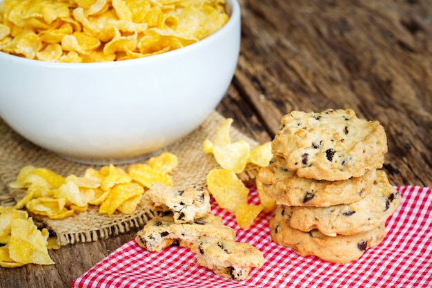 Frühstückskonzept, Plätzchen und Corn-Flakes auf Tabelle.