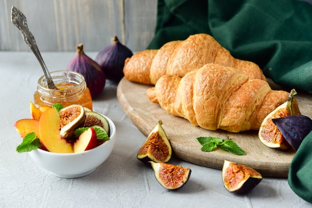 Frühstücksmenü mit Croissant, frischer Apfelmarmelade und Obstsalat