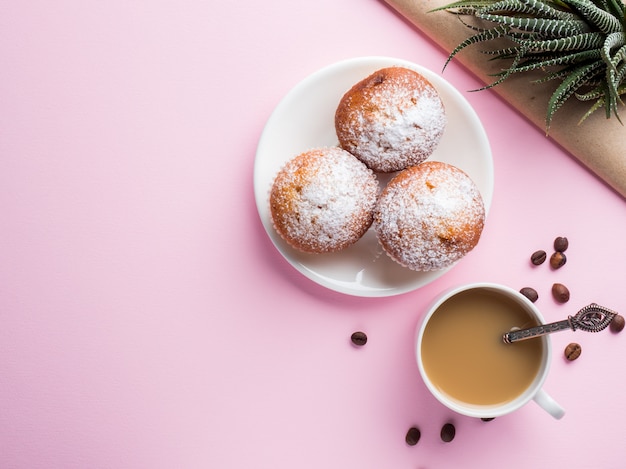 Frühstücksmuffinkaffee-Milchkrug auf einem rosa Hintergrund. Draufsicht flach legen.