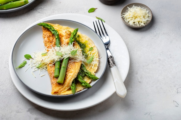 Frühstücksomelett mit Spargel, Pesto und Käse auf einem weißen Teller