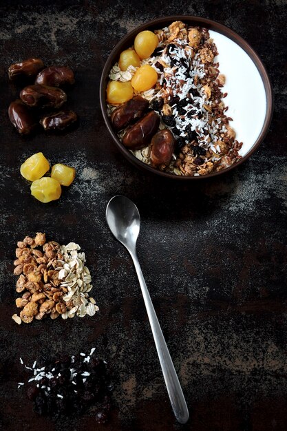 Frühstücksschale mit griechischem Joghurt, Haferflocken, Müsli und getrockneten Früchten.