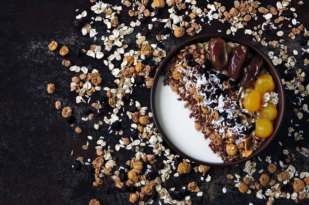 Frühstücksschale mit griechischem Joghurt, Haferflocken, Müsli und getrockneten Früchten.