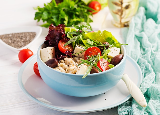 Frühstücksschüssel mit Haferflocken, Tomaten, Käse, Salat und Oliven. Gesundes Essen. Vegetarische Buddha-Schale