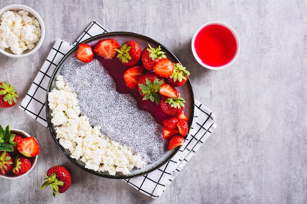 Frühstücksteller mit Quark-Chia-Pudding-Marmelade und Erdbeeren auf dem Tisch