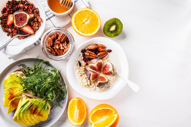 Frühstückstisch des strengen Vegetariers mit Avocadotoast, Hafermehl, Frucht, auf Weiß